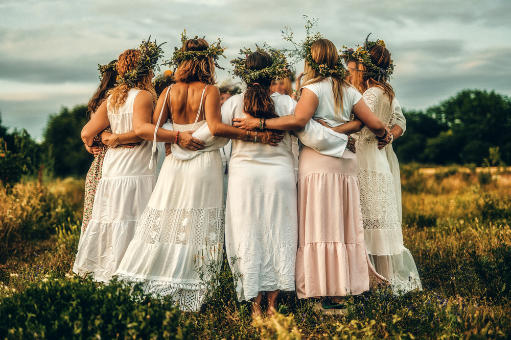 Women in flower wreath on sunny meadow, Floral crown, symbol of summer solstice